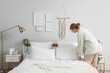 © Pixel-Shot - Female interior designer adjusting pillow in bedroom