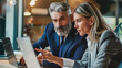 © Kashif - Two busy business people entrepreneurs using laptop at work in office. Two busy business people entrepreneurs team checking data using laptop at work in office. Mature executive manager talking to col