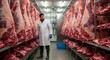 © dedy - Butcher carefully examines fresh slaughtered beef halves in cold storage facility