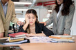 © bongkarn - Upset asian businesswoman resting head on one hand while getting comfort at working table in office.
