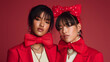 © CatNap Studio - Christmas and generation alpha: Two stylish women radiating confidence in red festive attire for an editorial shot, capturing holiday spirit and fashion
