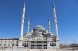 Frontal view of Kocatepe Mosque with central dome, tall minarets, marble facade and steps; religion, architecture, travel .
