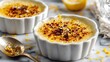 © fivan - Citrus creme brulee in ceramic dishes, marble background, scattered zest, airy bright light, copy space