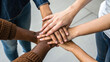 © LOMOSONIC - Multiple hands stacked together showing unity and teamwork with diverse skin tones and casual clothing