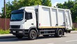 © DreamGrid - A white garbage truck stands in profile—clean, enclosed, hydraulically poised. A metaphor for civic cleansing and the choreography of urban discard.