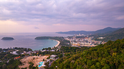 Wall Mural -  A stunning aerial view of the Andaman Sea at sunset, overlooking a coastal town in Phuket, Thailand. The golden hues of the sky reflect beautifully on the calm ocean waters, creating a tranquil
