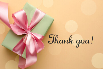 Wall Mural - Thank you card design with gift box on dark beige background, bokeh effect