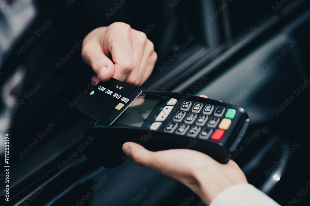 Person conducting a contactless payment with a credit card at a ...