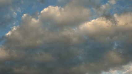 Wall Mural - Late day colored clouds moving across the sky with small areas of light blue