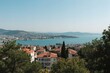 Scenic outlook of an urban harbor with water, sky, and beach in summer, featuring nature, homes, and trees