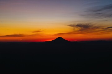 Wall Mural - vibrant sunset hues illuminating the dark mountain outlines