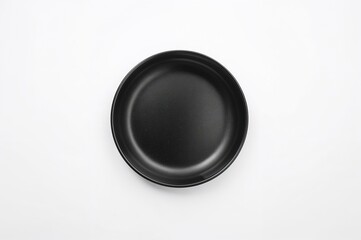 Wall Mural - Overhead perspective of a solitary blank black ceramic dish on a white backdrop with clipping path.