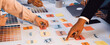 © InfiniteFlow - A vibrant workspace showcasing a team engaged in a brainstorming session. Colorful sticky notes and swatches reflect creative planning and collaboration efforts. SACTR