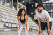 © anatoliycherkas - Couple of Athletes Recovering After Running on a Stadium Track