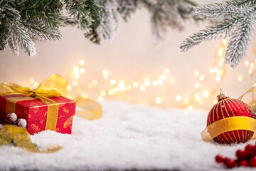 Wall Mural - festive red present with golden ribbon surrounded by gold ornaments, glittering star, and snowy pine