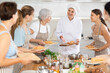 © JackF - Girl chef tells group of students listeners of cooking courses about secrets of cooking juicy and tender chicken fillet.