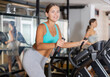 © JackF - Portrait of sporty young woman doing cardio workout on elliptical cross trainer at fitness center