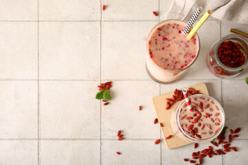 Wall Mural - Glasses of fresh goji berry smoothie with mint on white tile background