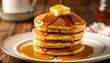 © Ai_Stock - Pouring maple syrup over a warm stack of fluffy breakfast pancakes.