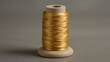 © James - A spool of metallic gold sewing thread neatly wrapped around a wooden base, used for crafts, embroidery, and design.