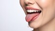© Ariskashobirin - Close-up of a smiling woman's mouth, tongue extended, with saliva.