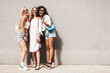 © halayalex - Three young beautiful smiling female in trendy summer clothes.Sexy carefree multiracial women posing on the street background near wall.Positive models having fun in sunglasses. Cheerful and happy