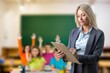 © BillionPhotos.com - Portrait of mature happy teacher stand in the class background