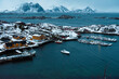 © Cavan Images - Snowy Coastal Village with Boats and Mountains