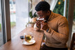 © djoronimo - Young man sitting in bar, relaxing and drinking tea. He is blowing nose.