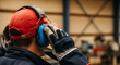 © MUHAMMAD - Protection First Worker with Earmuffs and Gloves Ensuring Workplace Safety Awareness