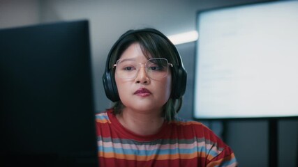 Asian Female Software Developer Concentrating on Programming Artificial Intelligence, Writing and DevelopingMachine Learning Code, Reviewing Data sits at office desk in software company office.