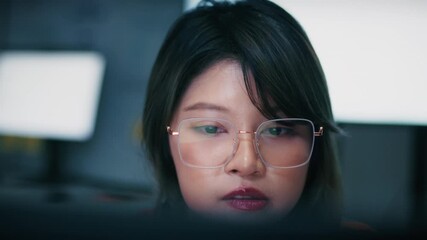 Female Computer Programmer working on Computer Writing and Developing Software Program, App looking at Dual screens in Creative Office workspace. Focused Professional female software developer work.