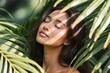 © Dima Anikin - A serene portrait of a graceful woman among lush green leaves, capturing her natural beauty and calmness