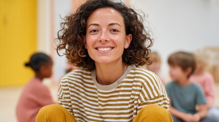 Woman smiling in classroom with children.