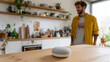 © AkB - Homme utilisant une enceinte connectée dans une cuisine moderne, concept de maison intelligente et technologie vocale