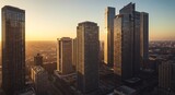 Aerial view of modern skyscrapers at sunset with golden light illuminating the city skyline