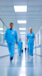 © Curioso.Photography - Group of doctors and nurses in blue scrubs walking through hospital corridor.