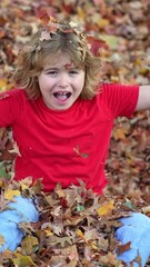 Wall Mural - Autumn child throws leaves. Child throwing up leaf. Kid plays with leaves. Joyful autumn leaf toss. Child throws leaves up. Autumn child tossing leaf. Kid throwing leaves with joy. Autumn fall.