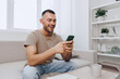 © SHOTPRIME STUDIO - Happy man engaging in a calming phone call, surrounded by a serene home environment. The scene reflects modern living and emotional well-being.