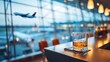 © ERiK - Whiskey glass at airport bar with airplane in background – travel and lifestyle concept