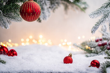 Wall Mural - festive red baubles rest on snow beneath frosted pine branches and golden holiday lights in the back