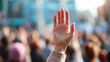 © mila103 - In a bustling city square individuals gather under the warm afternoon light raising their hands to show solidarity.