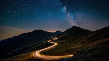 Wall Mural - A winding road cuts through a mountainous landscape illuminated by car lights, with a brilliant display of stars and the Milky Way overhead at night.