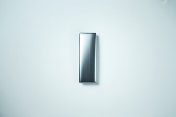 A single metal rectangular object on white surface