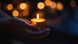© Kelumlakmal - a candle in memory of those lost to AIDS, symbolizing remembrance and advocacy, with a dimly lit blurred background