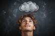 © du - Young man with tousled hair looking upwards thoughtfully at a chalk-drawn cloud on a blackboard expressing contemplation and imagination