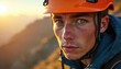 © Pete - Young caucasian male climber, focused expression, outdoors at sunrise. Rugged athlete wearing orange helmet, jacket, showing determination, grit on mountain slope. Journey of endurance, adventure.
