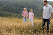 © BGStock72 - Family enjoying a sunny day outdoors in a grassy field with hills in the background