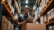 © Budi Jaya - Focused warehouse employee managing inventory with a digital tablet device