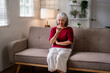 © snowing12 - Asian older woman speaks smartphone voice message home living room couch modern technology senior communication connection lifestyle